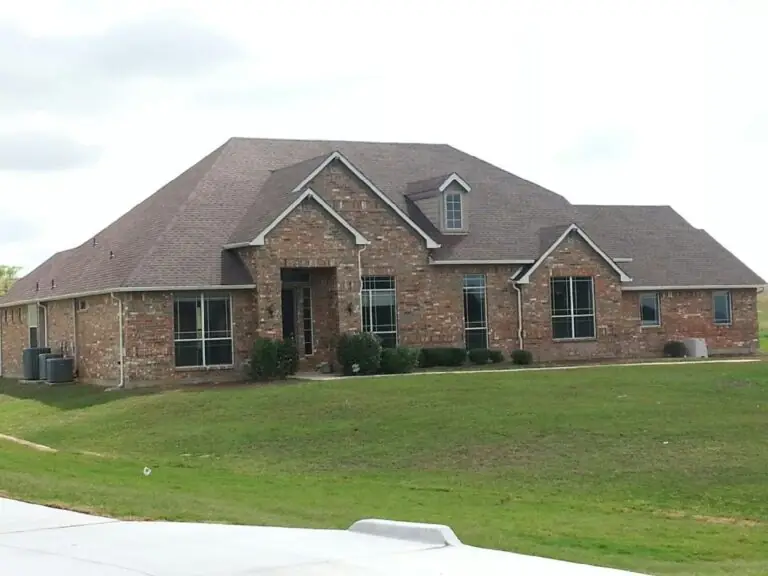 Brick home with a shingle roof by Ace Renovations Roofing & Gutters
