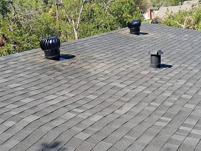 Two black turbine roof vents installed on an existing shingle roof in Wichita Falls